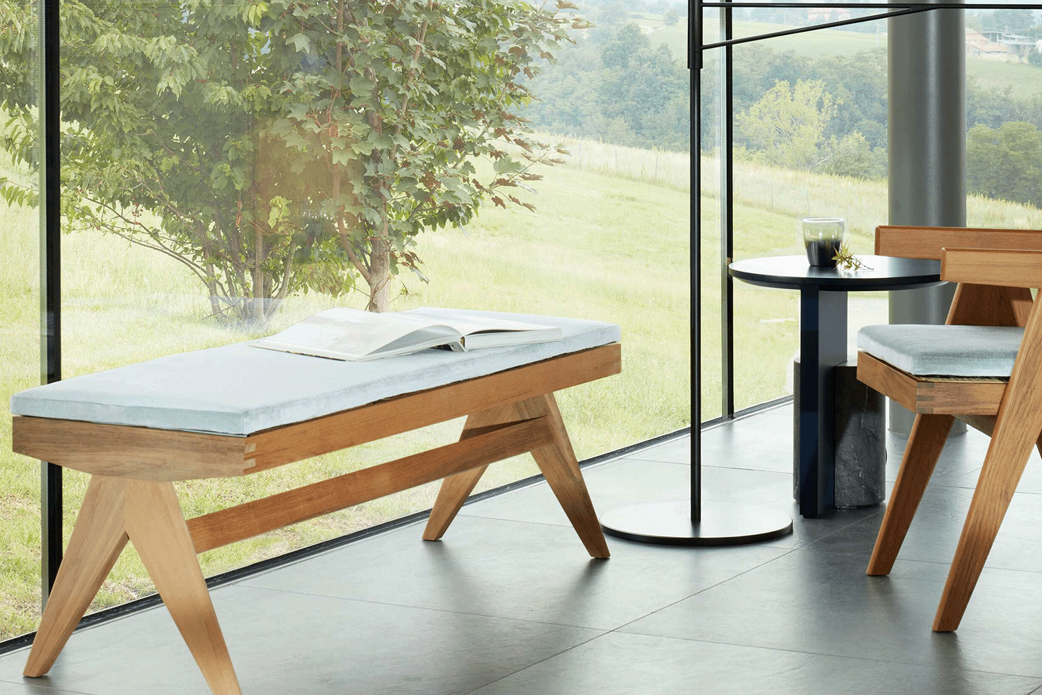 Die Bank Civil Bench mit dem Stuhl Capitol vor einer grossen Fensterscheibe mit gr&uuml;nem Hintergrund. 